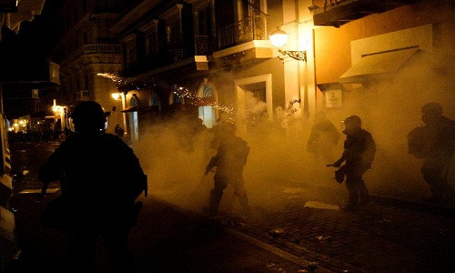 Hơi cay mù mịt trên đường phố San Juan. Đụng độ đã xảy ra giữa lực lượng cảnh sát và người biểu tình quá khích.