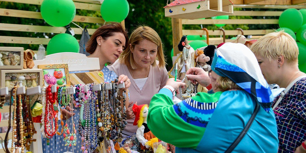 Một phụ nữ bán các tác phẩm nghệ thuật thủ công từ gỗ tại lễ hội "Cánh đồng Nga" ở Moscow.