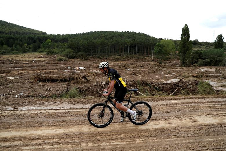 Người đàn ông đạp xe qua khu vực ngập lụt ở Pueyo vì mưa lớn.