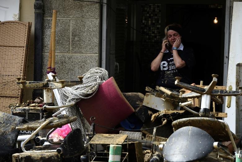 Người phụ nữ ở Tafalla ngán ngẩm khi phải dọn dẹp đống đổ nát sau khi mưa lũ đi qua.