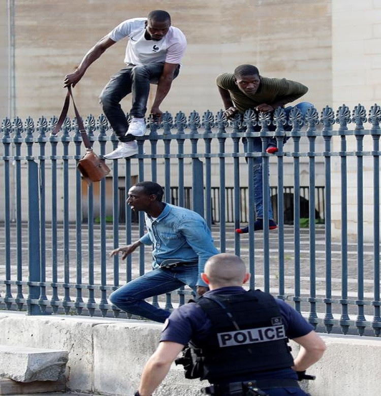Các di dân trèo qua hàng rào tại khu điện Pantheon.