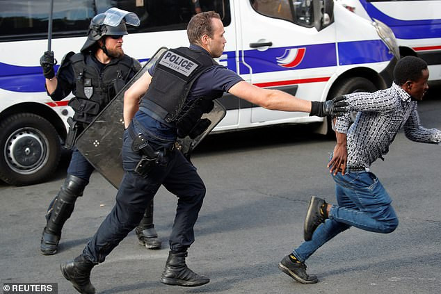 Một người biểu tình tháo chạy khi cảnh sát được triển khai tới khu điện Pantheon ở trung tâm Paris.