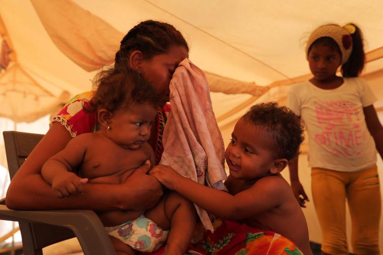 Người phụ nữ Venezuela bật khóc khi bế các con của cô trong khu trại tị nạn của Liên Hợp Quốc ở Maicao, Colombia, ngày 6/5. Mời độc giả xem thêm video: Hành trình gian khổ của người tị nạn Syria trên đất Châu Âu (Nguồn: VTC14)