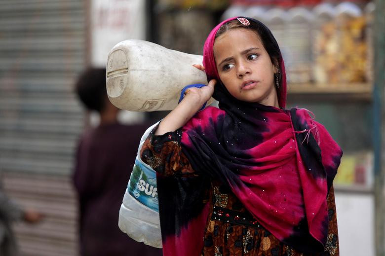 Bé gái Afghanistan đi lấy nước tại khu dân cư thu nhập thấp ở Lahore, Pakistan, ngày 20/6.