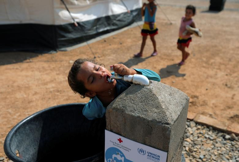 Bé gái Venezuela uống nước từ vòi trong khu trại tị nạn do Liên Hợp Quốc quản lý ở Maicao, Colombia, ngày 7/5.