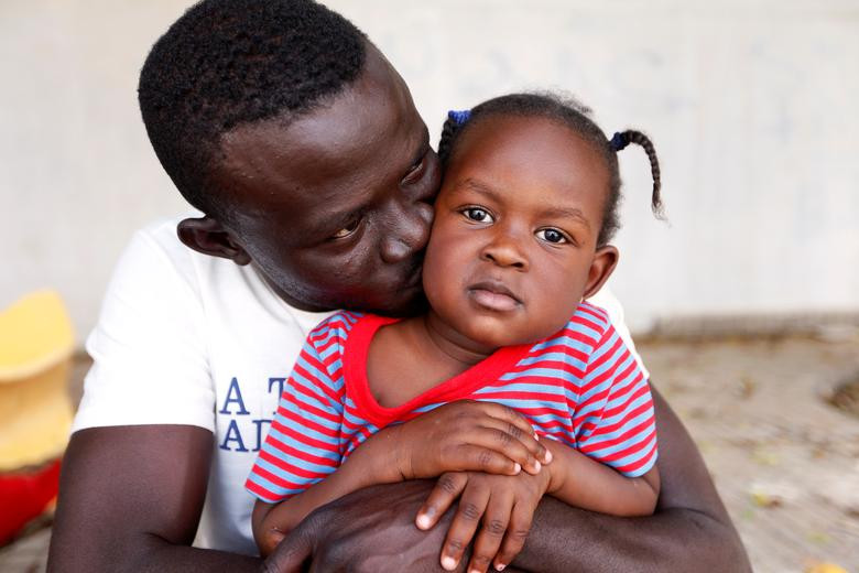 Hai bố con người Sudan đang ở trong một ngôi trường tại quận Al Dahra, thủ đô Tripoli, Libya, ngày 24/4 sau khi chạy trốn khỏi các cuộc xung đột trong nước.