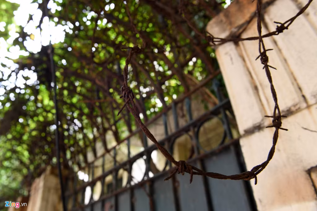 Bức tường dài gần 20 m được quấn chằng chịt dây thép gai bên trên như muốn ngăn cấm tuyệt đối những người tò mò bén mảng lại gần.