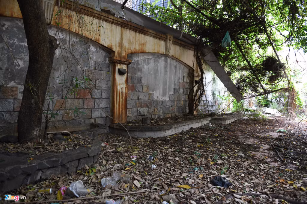 Bên trong khoảng sân rộng phía cửa trước ngập lá khô và rác, tường bong tróc hoen ố.