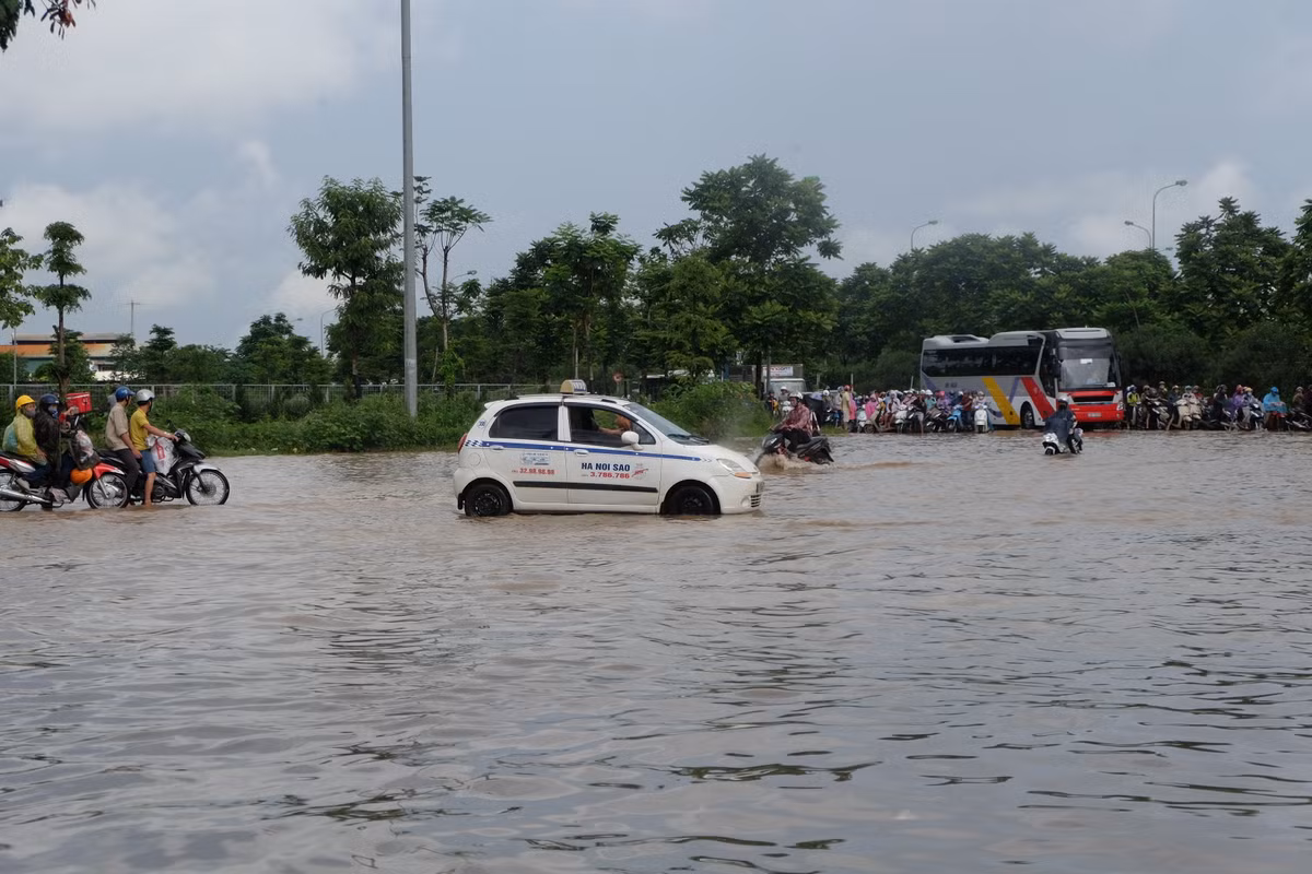 Một chiếc taxi phóng vội qua đoạn nước ngập.