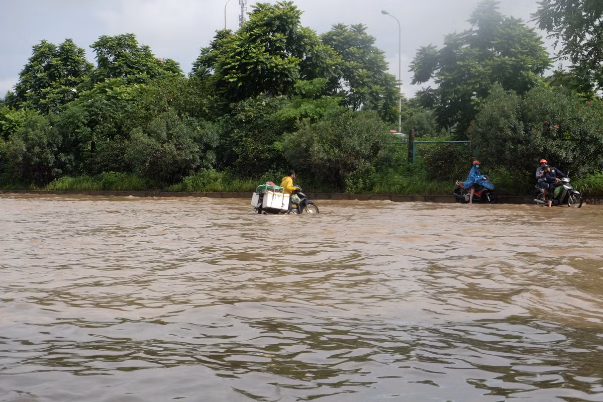 Một xe máy chở hàng vật vã tìm lối đi.