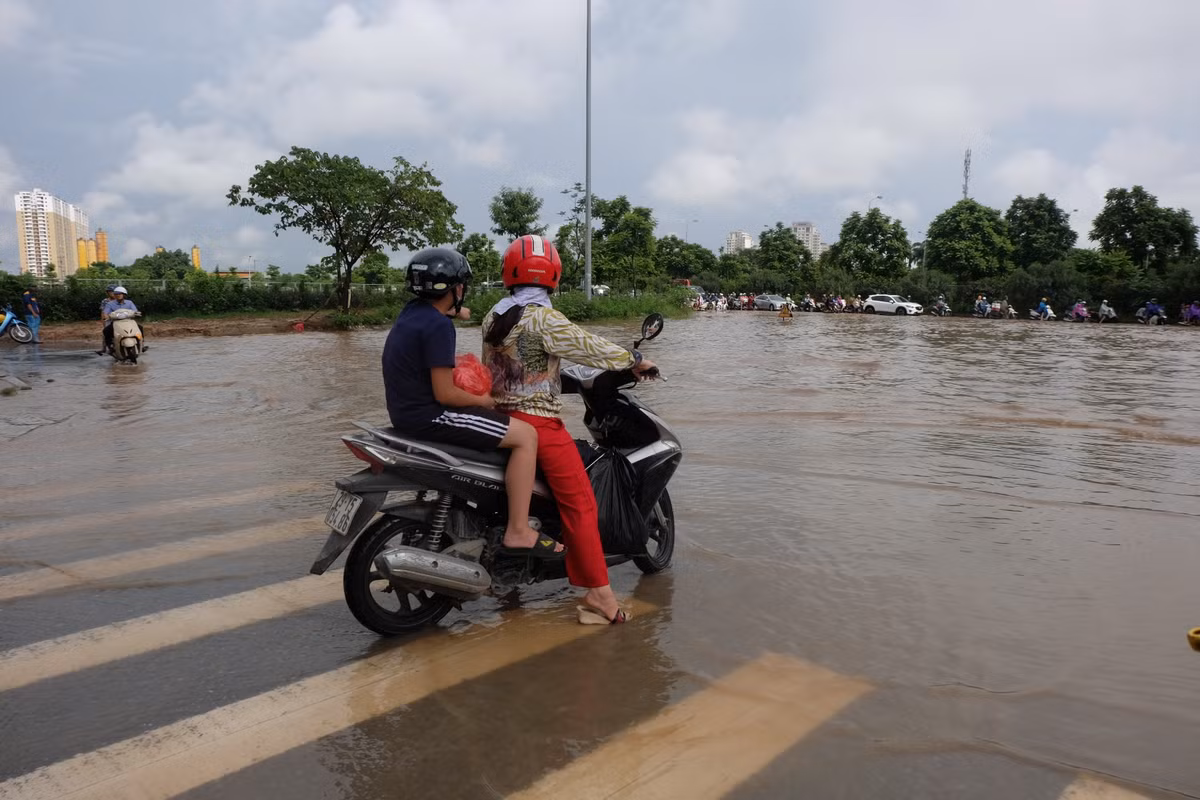 Đường bị chia cắt bởi "biển nước" sâu khiến nhiều người dân không thể di chuyển.