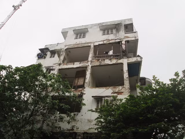 Phần hư hỏng nặng, cảnh báo nguy hiểm nhưng vẫn có người dân sinh sống, quần áo vẫn được phơi tại đây. Ảnh: Ngọc Thi.