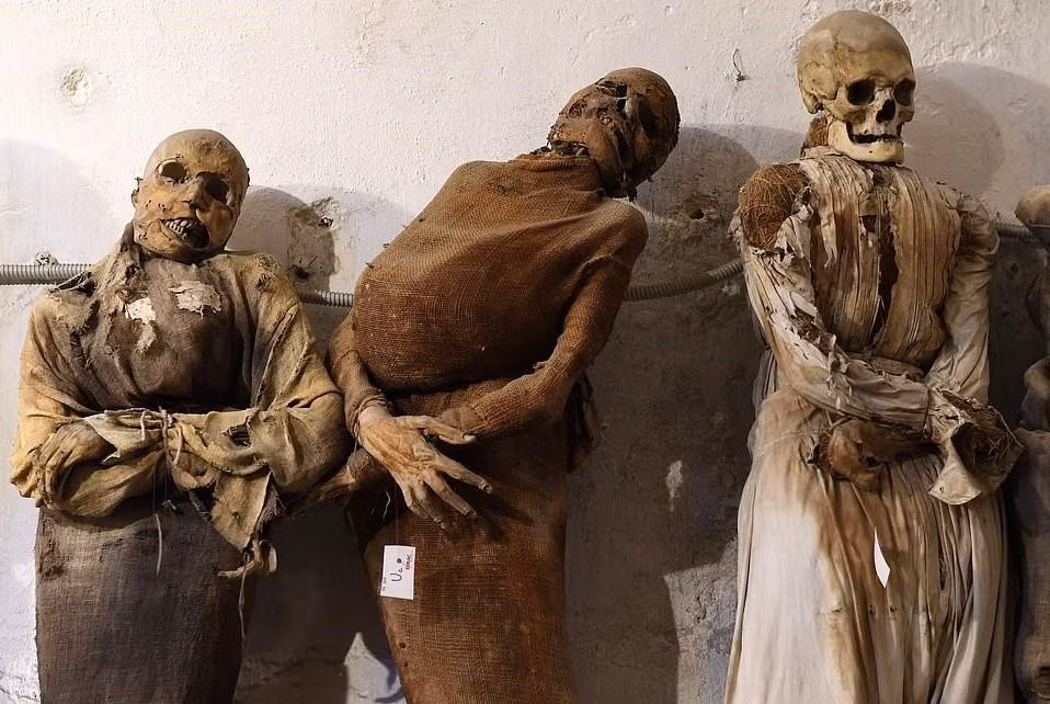 Ba xác ướp đứng cạnh nhau, người ở giữa vẫn còn móng tay, trong khi đó, người bên tay trái vẫn có một bộ răng đầy đủ.