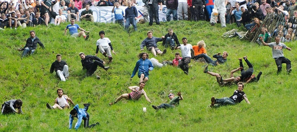 Mọi người hào hứng đuổi bắt miếng pho mát lăn xuống đồi bất chấp việc có thể bị ngã, rách quần áo... Lễ hội lăn pho mát có từ thế kỷ 15, tổ chức thường niên vào thứ 2 cuối cùng của tháng 5. Ảnh: Culture Trip.