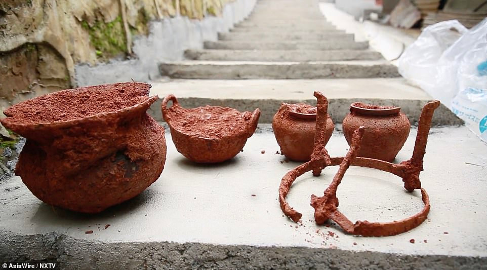 Các chuyên gia tiến hành làm sạch bụi đất từ các cổ vật trong ngôi mộ 1.000 tuổi trước khi đưa về bảo tàng.