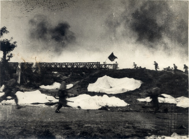 Một đơn vị phất cờ “Quyết chiến, quyết thắng” đánh chiếm cầu Mường Thanh, năm 1954. Ảnh: Trung tâm Lưu trữ quốc gia III thuộc Cục Văn thư Lưu trữ nhà nước.