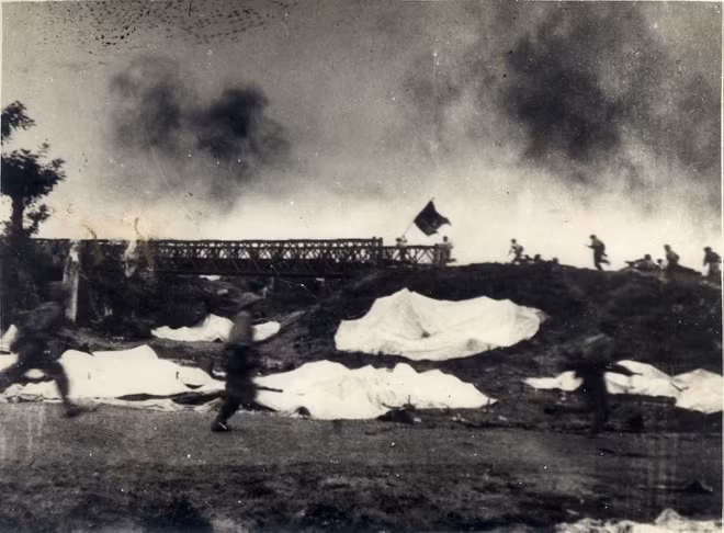 Một đơn vị phất cờ “Quyết chiến, quyết thắng” đánh chiếm cầu Mường Thanh, năm 1954. Ảnh: Trung tâm Lưu trữ quốc gia III thuộc Cục Văn thư Lưu trữ nhà nước.