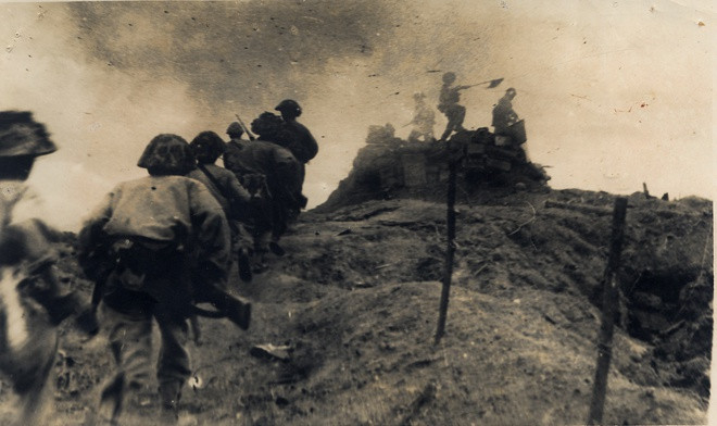 Quân ta xung phong lên chiếm cột cờ một lô cốt của địch ở Đồi C1 năm 1954. Ảnh: Trung tâm Lưu trữ quốc gia III thuộc Cục Văn thư Lưu trữ nhà nước.