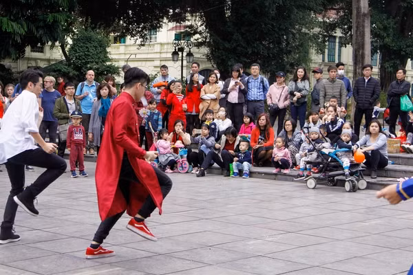 Người dân xung quanh hiếu kỳ chăm chú đứng xem màn biểu diễn.