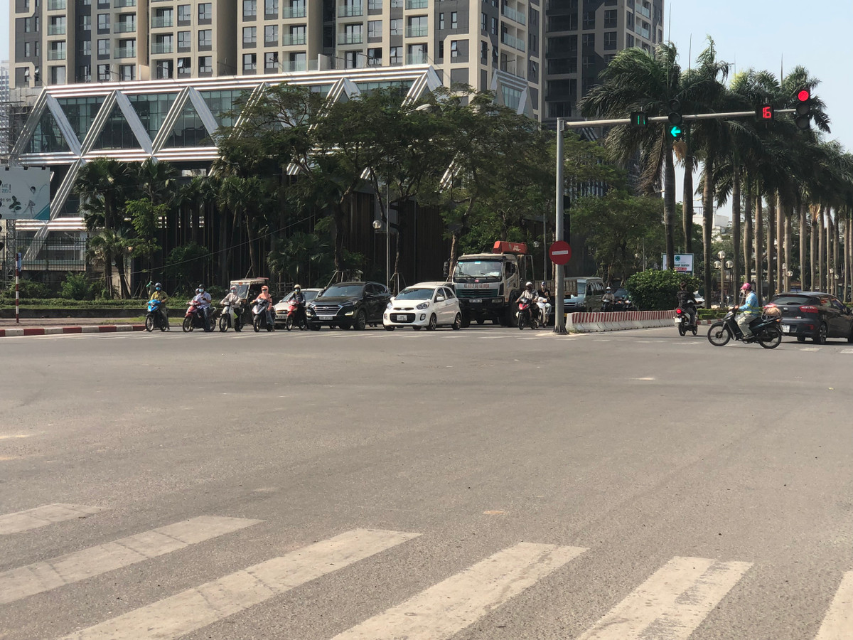 Các phương tiện tham gia giao thông đang dừng chờ đèn đỏ tại một ngã tư