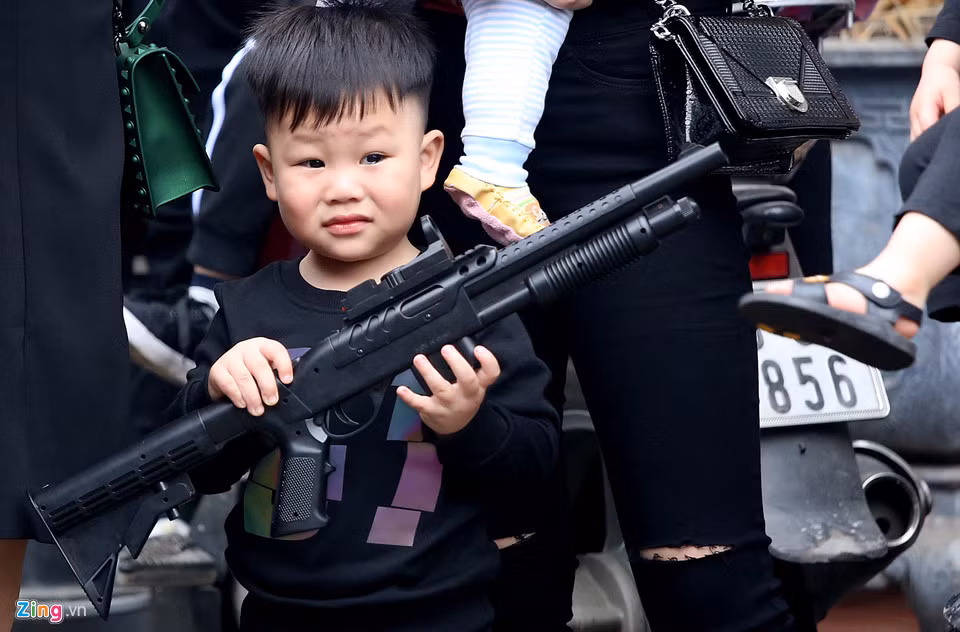 Tại sân làng Đồng Kỵ, hàng chục em nhỏ cầm trên tay những khẩu súng bắn bằng hơi.