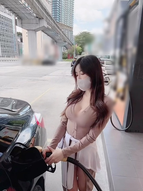 Hannah bung cúc áo trong lúc đổ xăng.