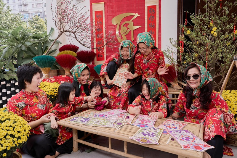 Gia đình nữ diễn viên mặc áo họa tiết chăn con công chụp ảnh đón Tết.