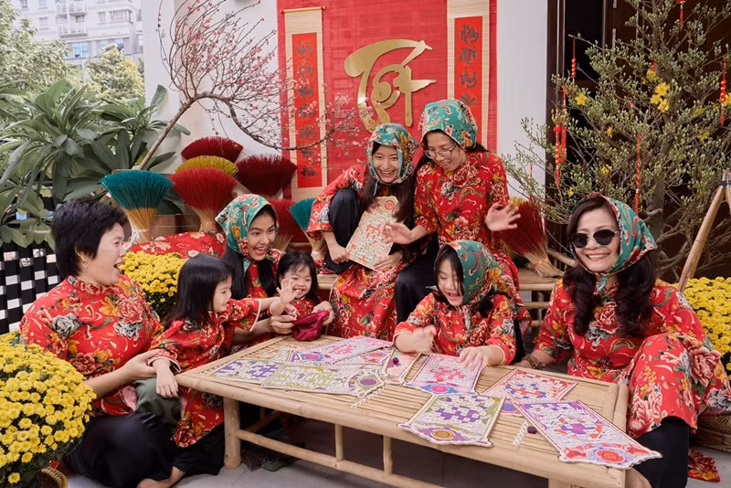 Gia đình nữ diễn viên mặc áo họa tiết chăn con công chụp ảnh đón Tết.