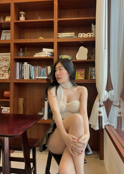 Diện váy ngắn, hot girl xinh đẹp tạo dáng phản cảm trong một quán cafe.