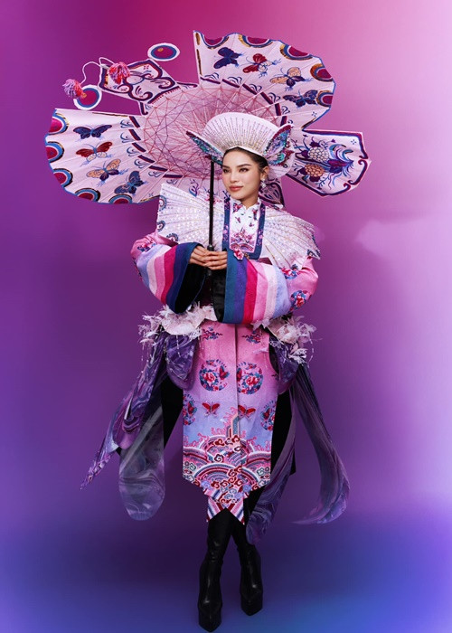 Thiết kế sử dụng các gam màu hồng, tím và xanh làm chủ đạo, tạo nên sự hòa quyện giữa nét nữ tính hiện đại và truyền thống. Các họa tiết cánh bướm sắp xếp khéo léo trên phần cánh tạo nên hiệu ứng sống động, tựa như một bức tranh nghệ thuật chuyển động theo từng vòng xoay của Kỳ Duyên.