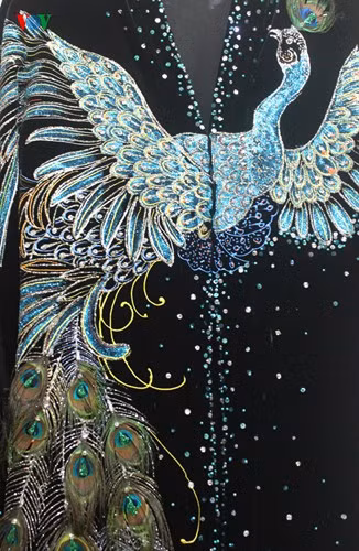 Nổi bật phía trước của áo là hình ảnh chú công đang dang rộng đôi cánh. Để làm nổi bật hình ảnh này, NTK Lý Minh Tuấn đã sử dụng chất liệu vải nhung đen 4 chiều của Ý giúp người mặc thấy thoải mái và mát lạnh.