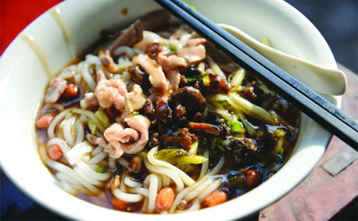 Mỳ “ôm mỹ nhân”. Tên món ăn bắt nguồn từ cảm nhận đầu tiên khi thực khách nhìn thấy nó. Những sợi mì dài, trắng phau xinh đẹp tựa như các cô gái được đặt giữa bát canh. Các nguyên liệu hòa trộn xung quanh nó khiến thực khách liên tưởng như đang ôm người đẹp.