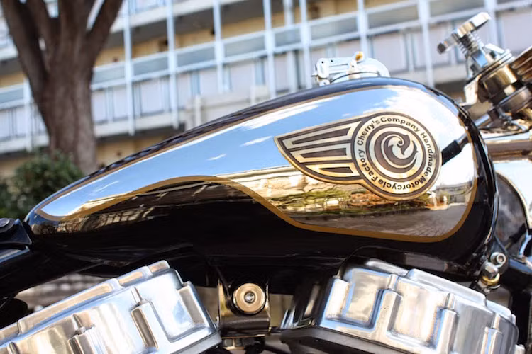 Hai bên bình xăng được sơn màu chrome, nhằm làm nổi bật cho logo của xưởng độ Cherry's Company được CNC từ một lá đồng.