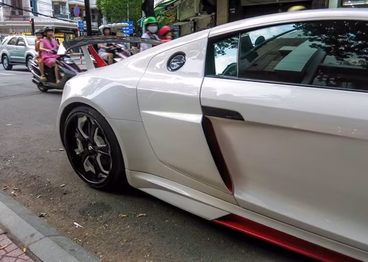 Gói độ Prior Design cũng bao gồm cả nẹp hông khí động học sau R8. Trên chiếc xe này, chủ xe cũng đã sơn lại phần ốp carbon phía sau cửa bằng màu trắng trùng với thân xe, đem tới vẻ đẹp mới khác biệt với những chiếc R8 khác.