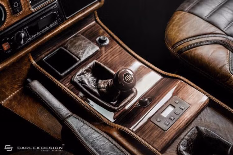 Gỗ cao cấp cũng là vật liệu được sử dụng để làm tất cả những chi tiết ốp trên xe. Trong khi đó, những chi tiết nhựa xấu xí của chiếc G-Class "zin" đã được Carlex bọc trong da.