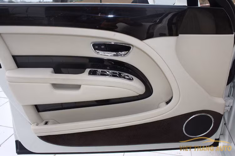 Các tấm ốp cửa hai bên xe bọc da trơn, không chần chỉ vân con thoi như bản Speed và những chi tiết ốp được Mulliner sử dụng loại gỗ cực kỳ tối màu, đem tới bề mặt gần như đen hoàn toàn.