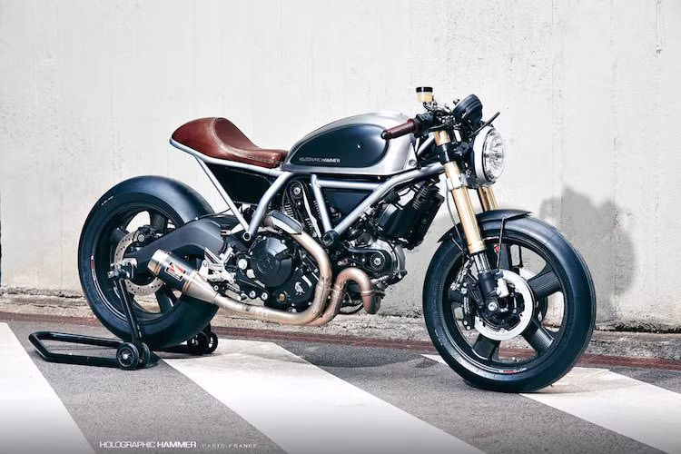 Ducati Scrambler Holographic Hammer: Là sản phẩm hợp tác giữa một cựu thiết kế của BMW, Ducati và tạp chí Moto Heroes, bản độ Ducati Scrambler nổi bật với kiểu dáng cafe racer thể thao và các phụ tùng "hàng hiệu" như mâm carbon Rotobox, phuộc USD Showa, phanh Beringer 4D...