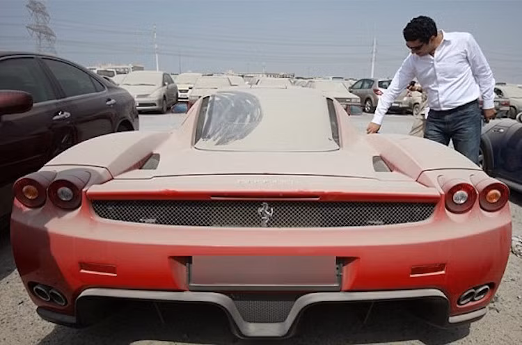 "Bóng dáng" của những chiếc siêu xe còn hiện diện ở ngay cả những bãi xe cũ tại Dubai, khi những chủ nhân cũ của chúng vì lâm vào khó khăn kinh tế hay vì một lý do bất đắc dĩ nào đó phải "bỏ của chạy lấy người", chẳng hạn như trường hợp của chiếc Ferrari Enzo phủ đầy bụi này.
