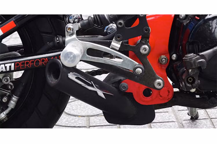 Bộ gác chân được gia công CNC từ nhôm, trong khi ống pô cũng đã được anh Toàn tự tạo ra. Tem nổi CX trên pô lấy từ chiếc tay ga Honda PCX nhưng bị "bẻ" chữ P đi.