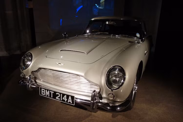 Aston Martin DB5 trong Goldfinger (1964): Mẫu xe dành riêng cho James Bond (Bondmobile) nổi tiếng nhất, và là chiếc đầu tiên được gắn các trang bị đặc biệt cho chàng điệp viên này bao gồm; súng máy giấu sau đèn xi-nhan, khiên chống đạn, biển số đổi được, trục bánh có cưa xé lốp...