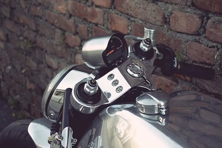 Chảng 3 trên được tiện CNC nguyên khối nhôm, sau đó mạ chrome bóng. Hai bên là tay lái clip-on đậm chất cafe cùng cùm ga Domino.