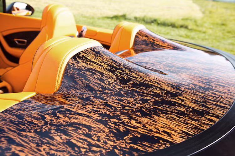 Nắp che mui của chiếc xe được làm bằng loại gỗ sơn mài đặc biệt, đem tới hoa văn "loang lổ" màu vàng đầy tính khoe mẽ.