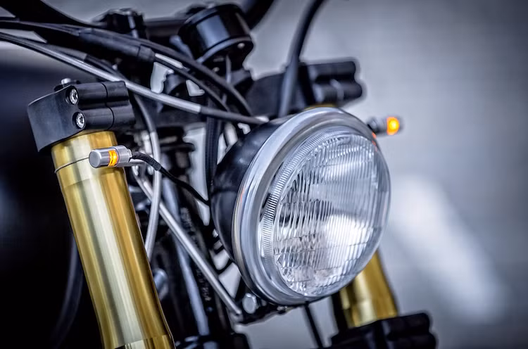 Phần đầu của chiếc Triumph có đèn pha của Bates, nhưng đèn xi-nhan đã được độ lại với bóng LED bọc trong 2 khối nhôm CNC cực nhỏ, khiến chiếc xe trông gọn gàng hơn.