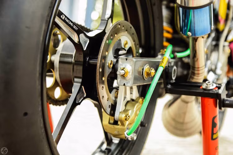 Đĩa sau của xe lấy từ Yamaha Exciter, kèm theo heo Brembo 2 pis đối xứng bắt ngược. Chiếc Z125 lăn bánh trên bộ mâm Racing Boy 5 cây CNC đắt tiền, cùng với lốp trơn như xe đua.