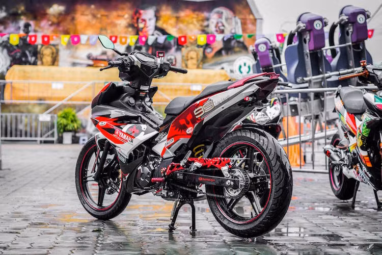  Exciter 150 Duka Family được độ lại với dàn vỏ được sơn tem đấu mang tông màu đỏ-trắng-xám tương phản ấn tượng.