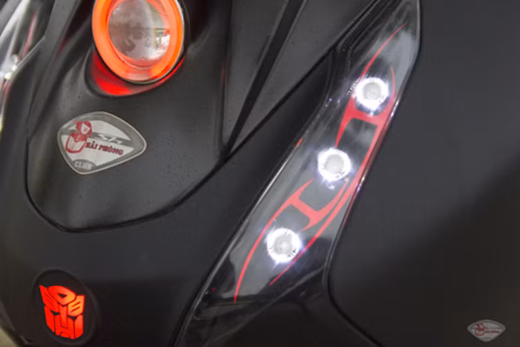 2 bên đèn xi-nhan nguyên bản của xe cũng đã được chủ nhân độ lại thành đèn LED. Ở dưới mũi xe còn có thêm một logo Transformer được chiếu sáng phía sau bằng LED.