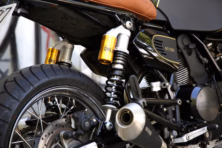 Workshop Madrid cũng không quên bọc lại yên xe bằng da màu nâu cafe, bên dưới yên là cặp phuộc Ohlins hàng hiệu. Động cơ của chiếc xe không có sự cải tiến nào, ngoại trừ cổ pô được làm lại để lắp vừa lon Spark mới.