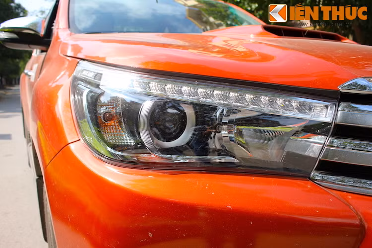 Cụm đèn pha cũng được nâng cấp với dải đèn LED ban ngày và đèn pha dạng thấu kính projector, càng khiến cho "bộ mặt" của Hilux trở nên gần gũi hơn với những "người anh em" sedan như Toyota Corolla Altis.