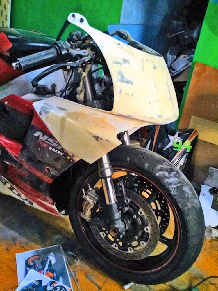 Phần quây gió cũ nát của chiếc xe được chế mủ, với đèn pha bịt hẳn lại theo phong cách chiếc xe đua MotoGP NSR500 trước đây.