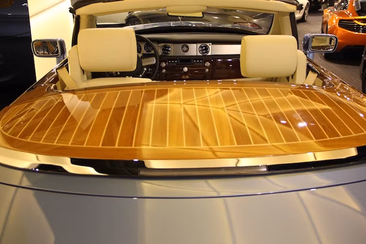 Ở phía trước kính chắn gió, chiếc xe có thêm 2 khoang chứa đồ nhỏ với nắp đậy được làm bằng gỗ. Tương tự, nắp che mui phía sau xe cũng là gỗ quý.